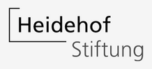 Das Logo der Heidehof Stiftung besteht aus dem schwarzen Schriftzug „Heidehof“, umgeben von einer offenen eckigen Linie. Unterhalb steht „Stiftung“ in grauer Schrift auf weissem Hintergrund.